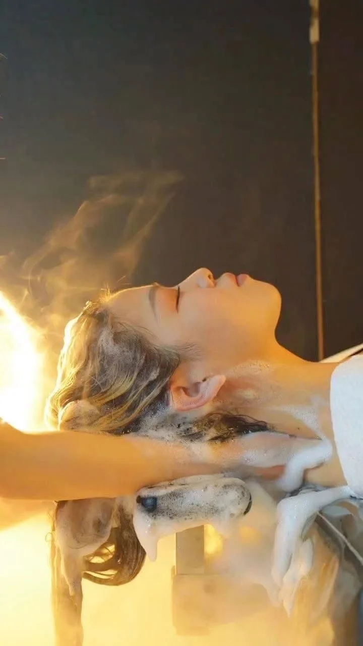 Warm golden steam rising at the head-wash basin during the signature ritual